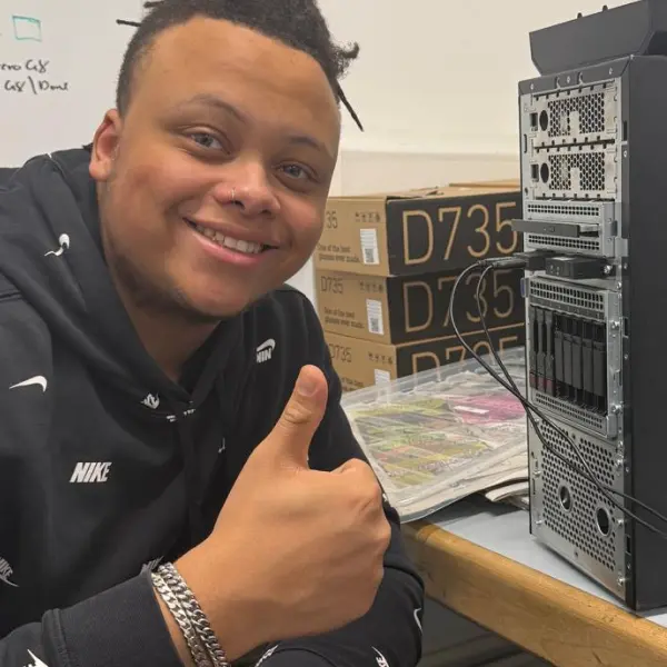 Mesh giving a thumbs up with a computer next to him